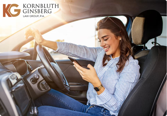 Portrait of a young woman texting on her smartphone while driving a car.